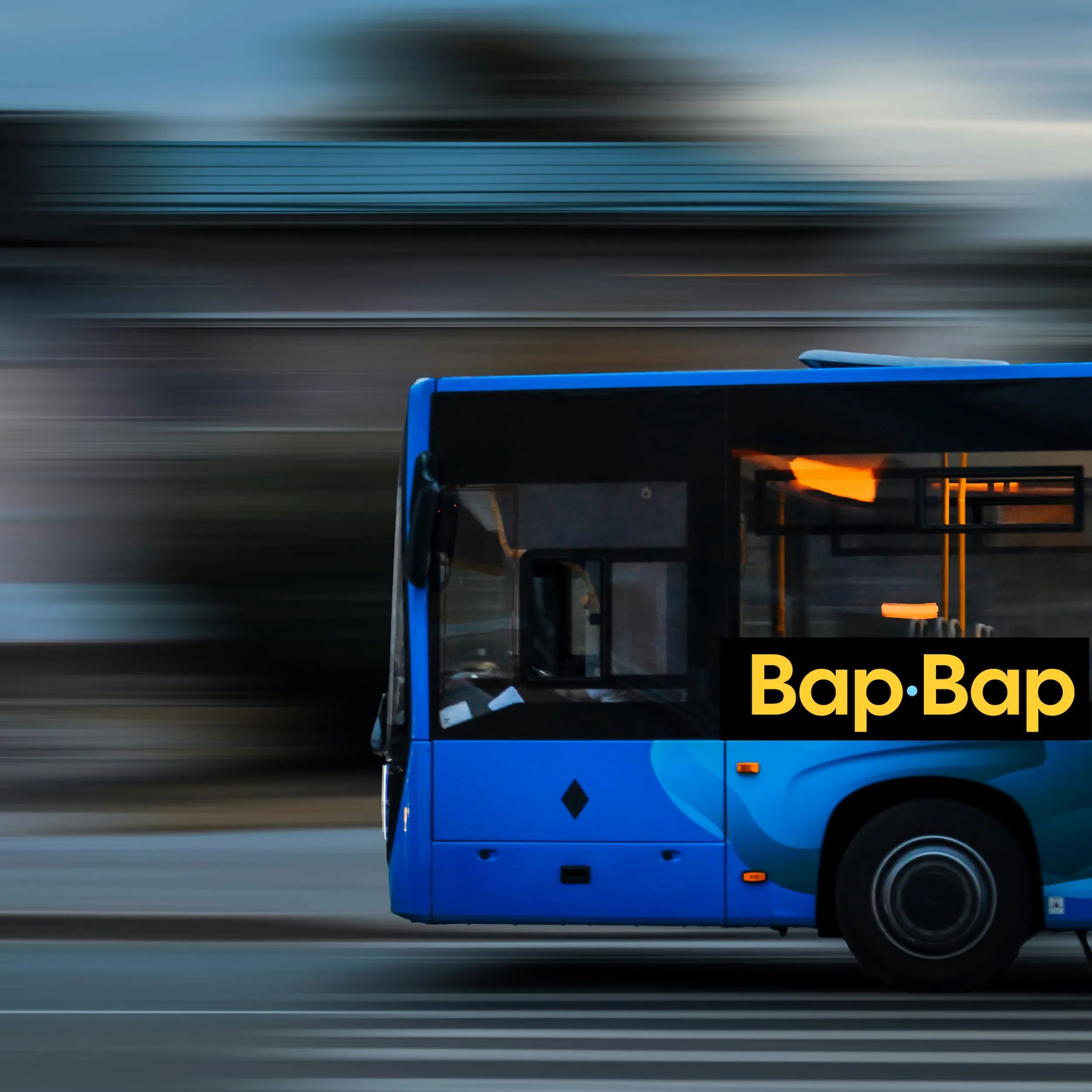A blue bus with the Bap·Bap logo on its side, speeding past a blurred street
